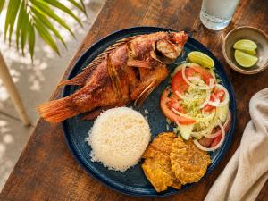 a plate of food with a fish and rice at Hotel San Luis Beach House By OxoHotel in San Andrés