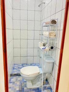 a bathroom with a toilet and a shelf with towels at Estadia colonial in Suchitoto