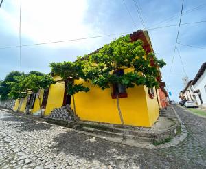 a yellow building with trees on the side of it at Estadia colonial in Suchitoto