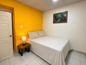 a small bedroom with a bed and a picture on the wall at Estadia colonial in Suchitoto