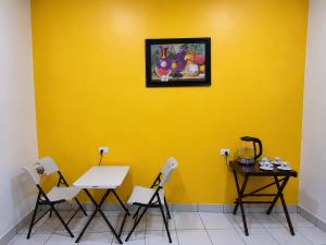 a yellow wall with a table and chairs in a room at Estadia colonial in Suchitoto