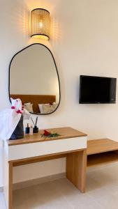 a mirror on a wall next to a table at Hôtel Archipel in Monastir