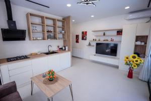 a kitchen and living room with a table and a tv at Modern Mountain Villa with Pool near Tbilisi in Bulach'auri