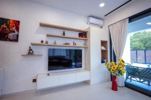 a living room with a large television and a window at Modern Mountain Villa with Pool near Tbilisi in Bulach'auri