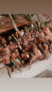 a group of men posing for a picture on the beach at Ocean View PLAYA DEL NIÑO Rooms & Apartments in Cancún