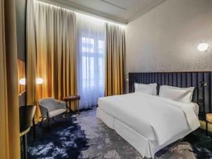 a bedroom with a large white bed and a window at Century Old Town Prague - MGallery Collection in Prague +185 photos