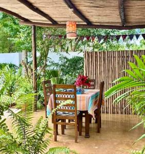 a table and chairs under a wooden pergola at Casa del Mar Diani in Diani Beach