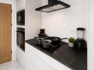 a kitchen with a counter with pots and pans on it at 3 Bed House , Bootle , Discounts , Long Stays , Contractors , Families , Relocation Stays in Liverpool