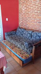 a bed in a room next to a brick wall at MALU casa quinta in Rafaela