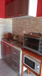 a kitchen with a microwave and a stove top oven at MALU casa quinta in Rafaela