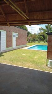 a backyard with a swimming pool and a brick building at MALU casa quinta in Rafaela