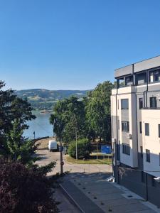 a building with a parking lot next to a body of water at Apartman Dejanović 2 in Veliko Gradište
