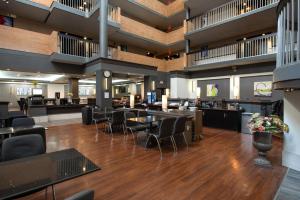 eine große Lobby mit Tischen und Stühlen und ein Restaurant in der Unterkunft Coast Calgary University Area Hotel by APA in Calgary