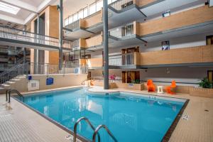 ein Hallenbad in einem Gebäude mit einem großen Schwimmbad in der Unterkunft Coast Calgary University Area Hotel by APA in Calgary