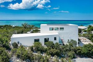 an aerial view of a white house on the beach at Beachwood Villa in Turtle Cove