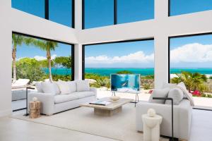 a living room with white furniture and a view of the ocean at Beachwood Villa in Turtle Cove +30 photos