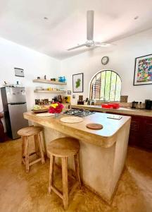 a kitchen with a large island with two stools at Casa del Mar Diani in Diani Beach +12 photos