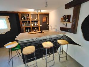 a bar in a room with stools around it at Čardak seosko domaćinstvo  +9 photos