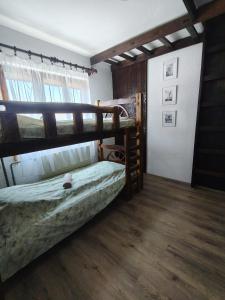 a bedroom with two bunk beds and a wooden floor at Čardak seosko domaćinstvo 