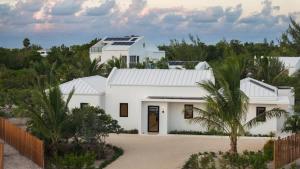 a white house with solar panels on the roof at Villa Seadream - Upper East Side Enclave #16 in Long Bay Hills