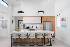 a kitchen with a large island with bar stools at Villa Seadream - Upper East Side Enclave #16 in Long Bay Hills +30 photos