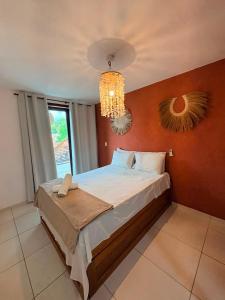 a bedroom with a large bed with a chandelier at Casa Macao Pipa in Pipa