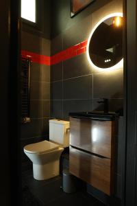 a bathroom with a toilet and a sink and a mirror at Lasuitesecretetdetente in Beauvais