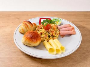 a plate of food with eggs sausage bread and croissants at Alko Select in Cali +36 photos