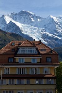 a building with a snow covered mountain in the background at Silverpeak in Wengen