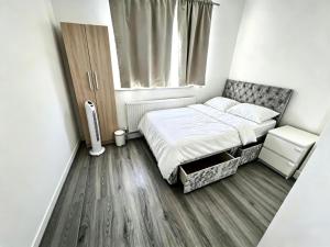 a small bedroom with a bed and a window at Chadwell Heath Rooms in Goodmayes