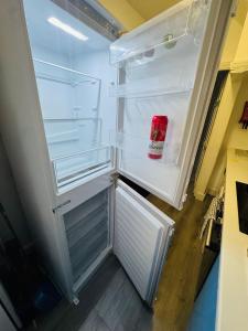 an empty refrigerator with its door open in a kitchen at Chadwell Heath Rooms in Goodmayes