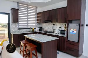 a kitchen with wooden cabinets and a counter top at Daviel Elite Apartments in Dodoma +4 photos