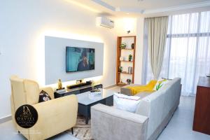 a living room with a couch and a tv at Daviel Elite Apartments in Dodoma