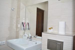 a white bathroom with a sink and a mirror at Amaras Boutique Hotel Lori in Stepʼanavan
