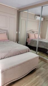 a bedroom with two beds and a large mirror at Próximo aSerra do Rio do Rastro in Lauro Müller