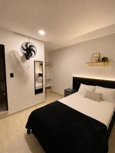 a bedroom with a large bed with a black blanket at Ortega La 33 Hotel y Spa in Medellín +10 photos