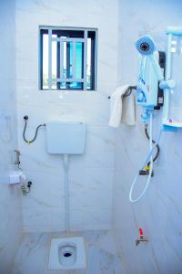 a white bathroom with a toilet and a window at JOSEPHINA LODGE Dodoma in Dodoma +70 photos