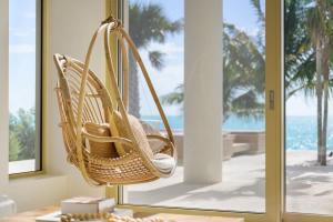 a swinging chair in a room with a view of the ocean at Kailoa Villa in Long Bay Hills
