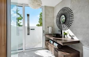 a bathroom with a sink and a mirror at Ocean Dream Studio Blue - Ocean View in Long Bay Hills