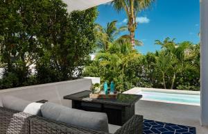 a patio with a table next to a swimming pool at Ocean Dream Studio Blue - Ocean View in Long Bay Hills