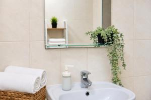 a bathroom with a sink and a mirror at Central City Balcony Apartments in Mukacheve +36 photos