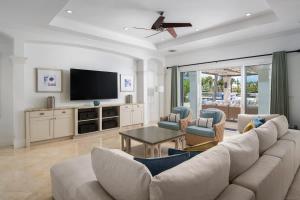 a living room with a couch and a tv at Abundance and Prosperity Villa in Long Bay Hills
