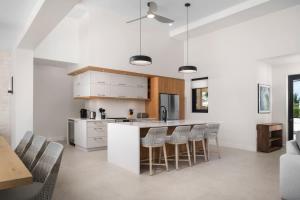 a kitchen with white cabinets and a bar with stools at Upper East Side Enclave # 18 in Leeward