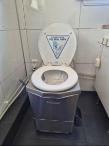 a bathroom with a toilet with the lid up at Cabin and Guest house in Haugesund
