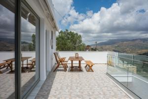 a patio with a table and chairs on a balcony at Cretan View - Valley & Mountains View Sitia in Áyios Yeóryios