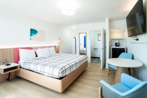 a bedroom with a bed and a table and chairs at The Belmont Shore Inn in Long Beach