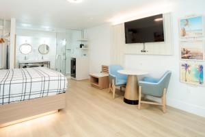 a bedroom with a bed and a table and chairs at The Belmont Shore Inn in Long Beach