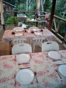 a table with white plates on it with chairs and a table sidx sidx at Miranda in Arroyo Chico Arriba +9 photos