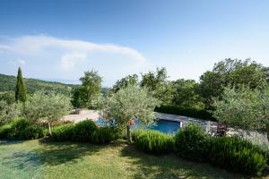 a garden with a swimming pool and trees at Villa Perugini in Tuoro sul Trasimeno
