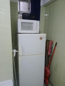 a microwave sitting on top of a refrigerator at Arco Iris in Miramar